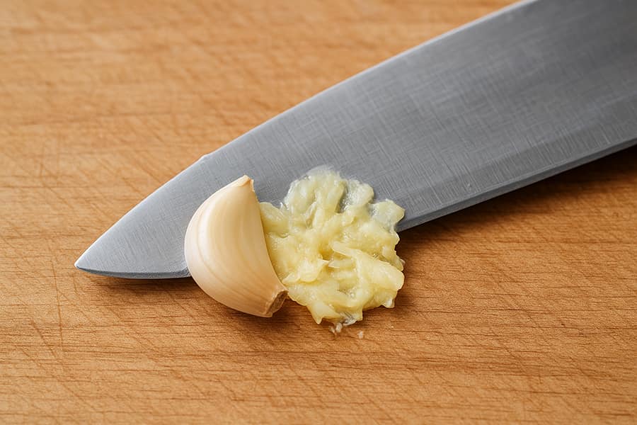 Peel the garlic and then smash it